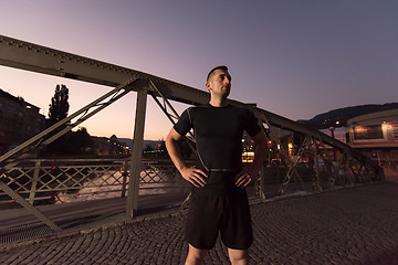 Image showing man jogging across the bridge in the city