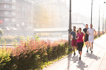 Image showing group of young people jogging in the city
