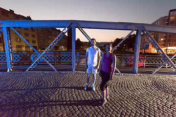 Image showing couple jogging across the bridge in the city