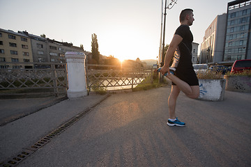 Image showing athlete man warming up and stretching