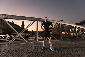 Image showing man jogging across the bridge in the city