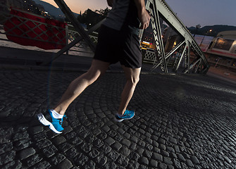 Image showing man jogging across the bridge in the city