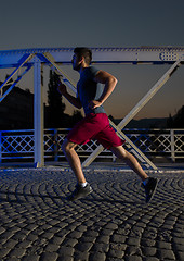 Image showing man jogging across the bridge in the city