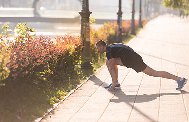 Image showing athlete man warming up and stretching