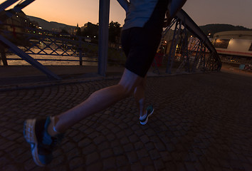 Image showing man jogging across the bridge in the city