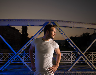 Image showing man jogging across the bridge in the city