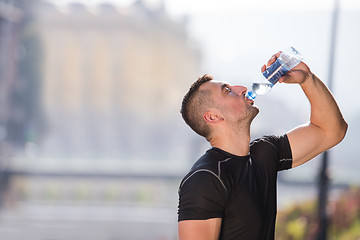 Image showing man drinking water from a bottle after jogging