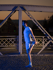 Image showing man jogging across the bridge in the city