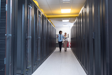 Image showing engineer showing working data center server room to female chief