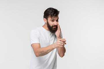 Image showing The young man whispering a secret behind her hand