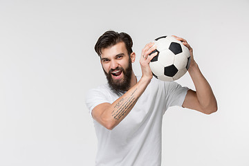 Image showing Young soccer player with ball in front of white background