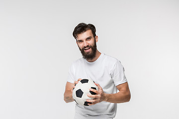Image showing Young soccer player with ball in front of white background