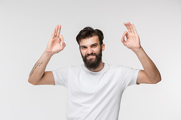 Image showing The happy businessman standing and smiling against white background.