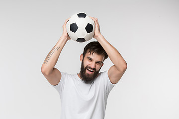 Image showing Young soccer player with ball in front of white background