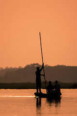 Image showing Men in a boat on a river silhouette