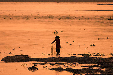 Image showing Asian Woman fishing in the river, silhouette at sunset