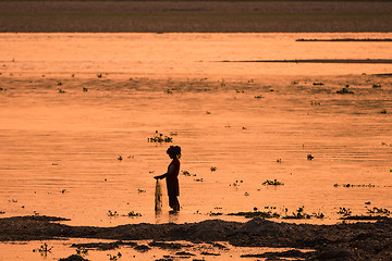 Image showing Asian Woman fishing in the river, silhouette at sunset