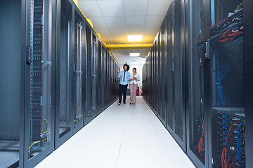 Image showing engineer showing working data center server room to female chief