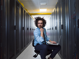 Image showing engineer working on a laptop in server room