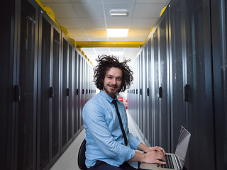 Image showing engineer working on a laptop in server room