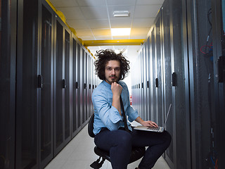 Image showing engineer working on a laptop in server room