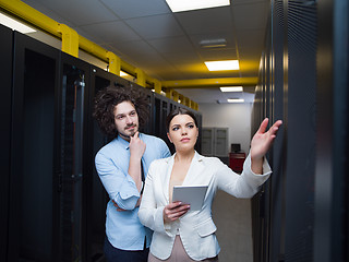 Image showing engineer showing working data center server room to female chief