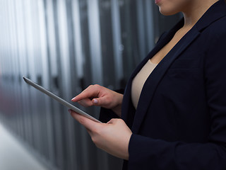 Image showing Female engineer working on a tablet computer in server room