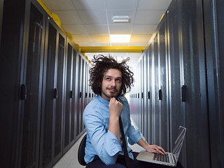 Image showing engineer working on a laptop in server room