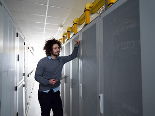 Image showing IT engineer working on a tablet computer in server room