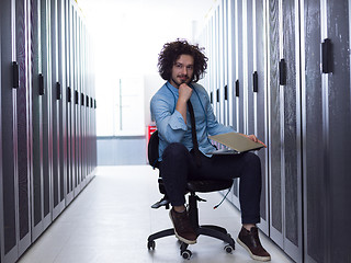 Image showing engineer working on a laptop in server room