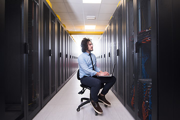 Image showing engineer working on a laptop in server room