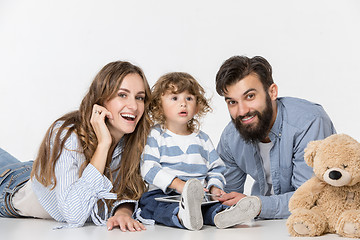 Image showing Smiling family sitting together in studio and watching their favorite cartoons on laptop