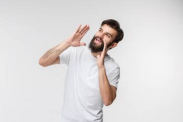 Image showing Isolated on pink young casual man shouting at studio