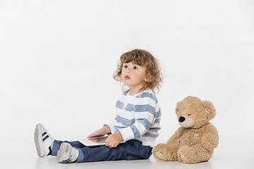 Image showing Portrait of happy joyful beautiful little boy sitting with laptop