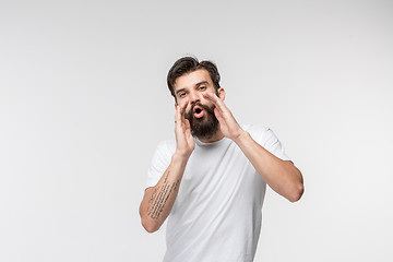 Image showing Isolated on pink young casual man shouting at studio