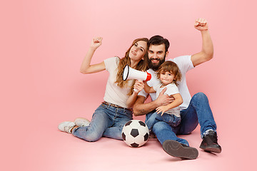 Image showing happy father and son playing together with soccer ball on pink