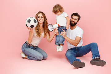 Image showing happy father and son playing together with soccer ball on pink
