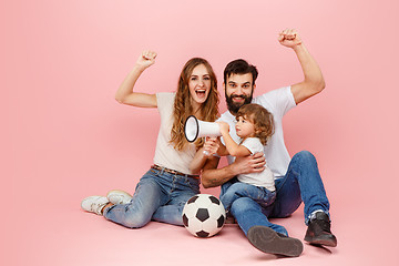 Image showing happy father and son playing together with soccer ball on pink