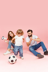 Image showing happy father and son playing together with soccer ball on pink