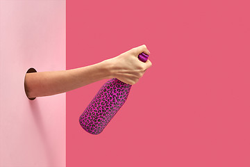 Image showing The thumb holds closed the wine bottle painted hot pink .