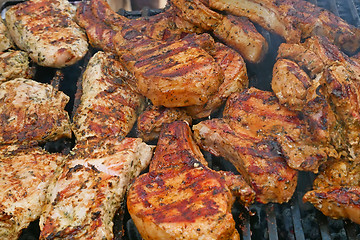 Image showing A lot of pieces of meat are roasted on metal bars