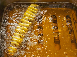 Image showing Potato slices are fried in oil in a deep fryer