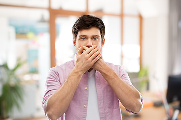 Image showing shocked man closing mouth by hands at office room