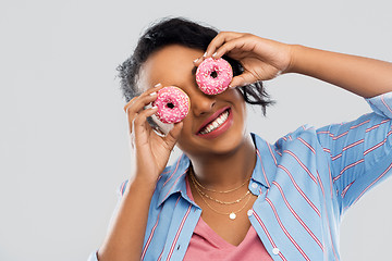 Image showing happy african american woman with eyes of donuts