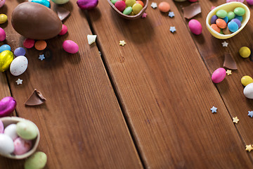 Image showing chocolate eggs and candy drops on wooden table