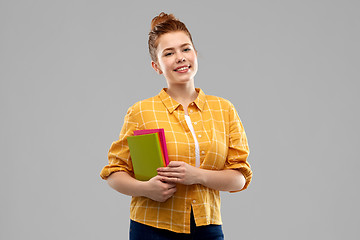 Image showing smiling red haired teenage student girl with books