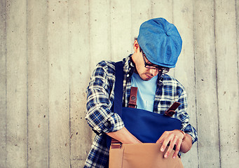 Image showing hipster man looking for something in his bag