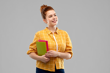 Image showing smiling red haired teenage student girl with books