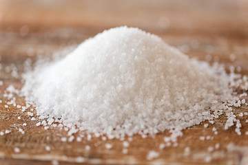 Image showing close up of white salt heap on wooden table