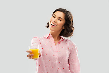 Image showing happy young woman in pajama holding orange juice